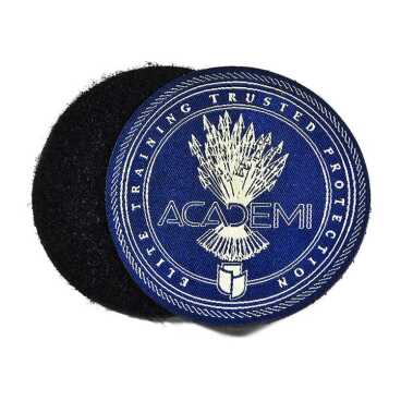 Blue circular patch with an emblem and text on a black fabric background.