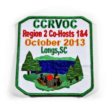 An embroidered patch with a campsite scene and event details.