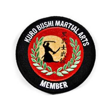 Martial arts patch with silhouette and laurel design, labeled 'KURO BUSHI MARTIAL ARTS MEMBER'.